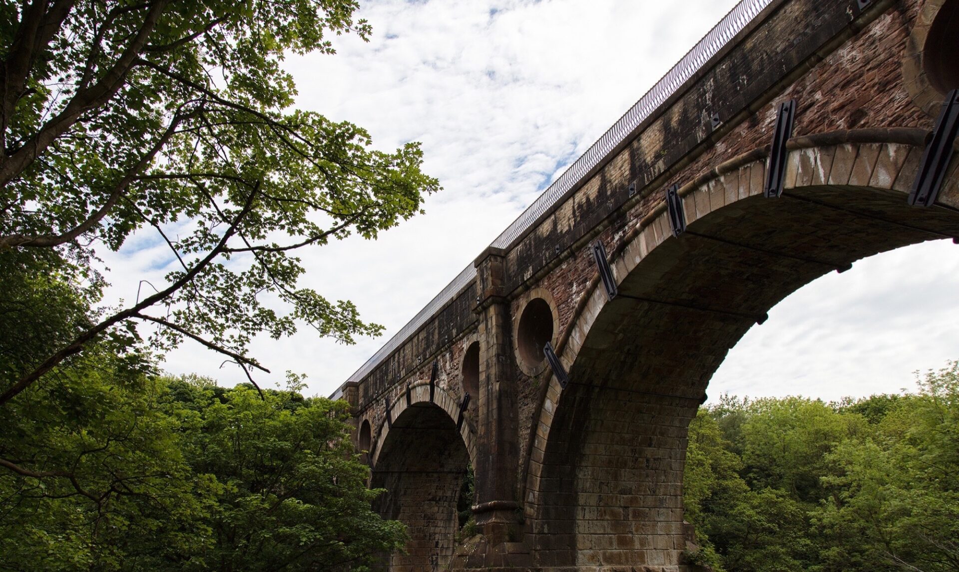 Ground view looking up at the Aqueduct with the parapet in distant view