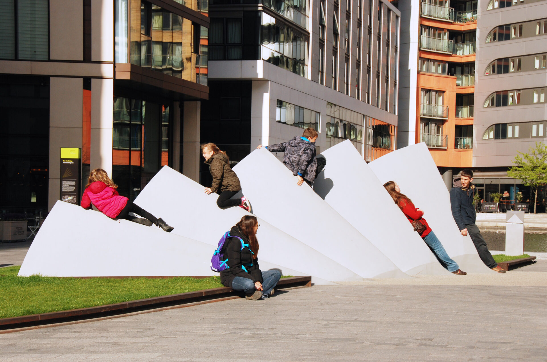 Children playing on the counterweights of Merchant Square Footbridge