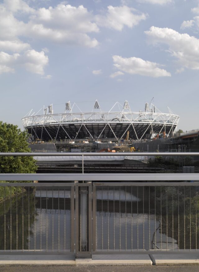 View from steel bridge parapet across river looking at the Olympic Stadium