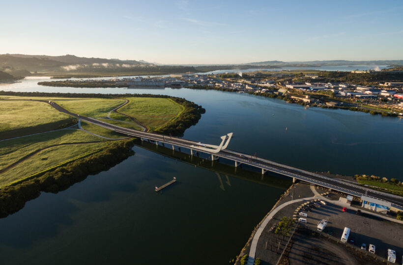Aerial view of bridge approaching the Lower Hatea bascule bridge with housing and green fields in the background