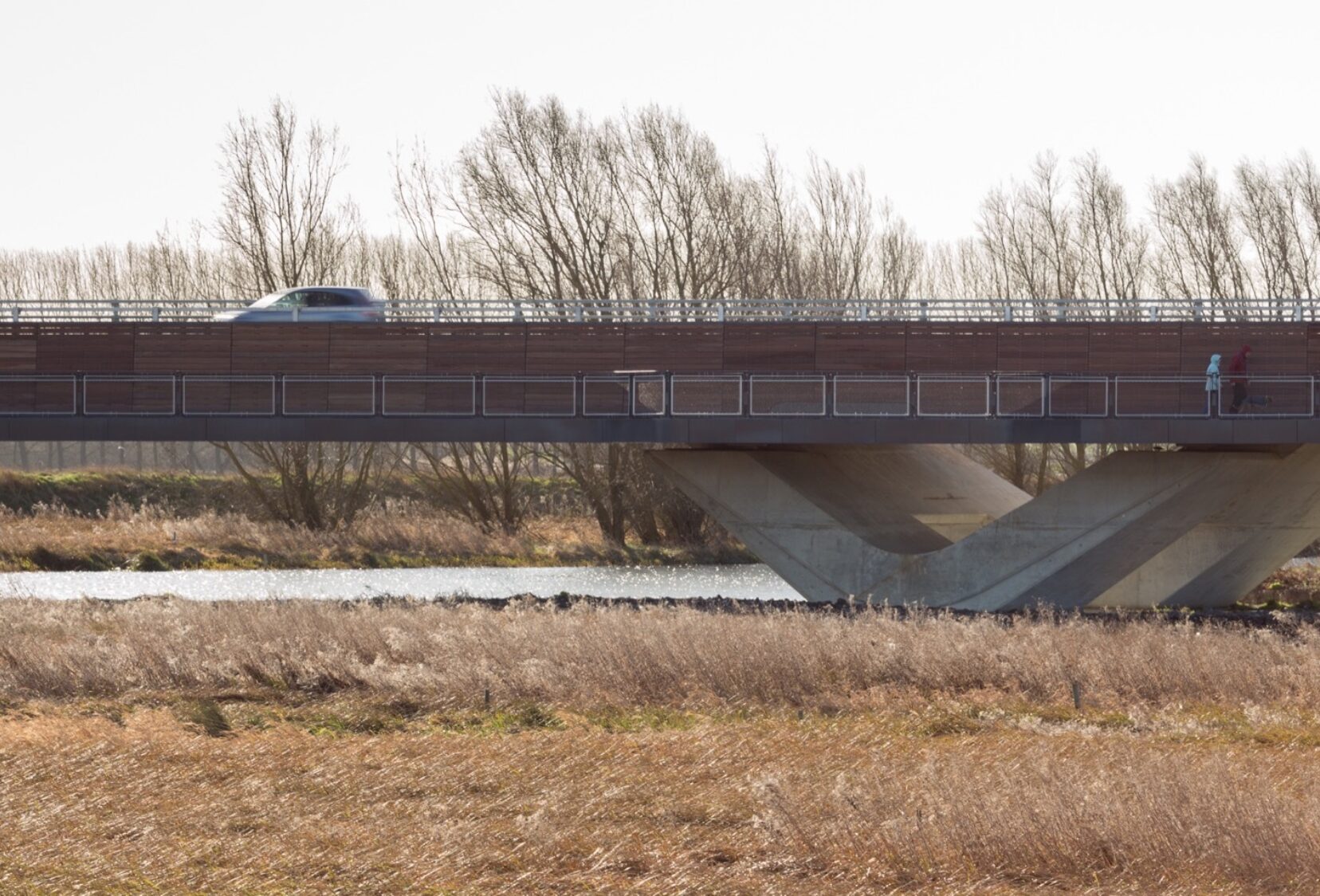 Car travelling and people walking on the Ely Bypass walkway and road