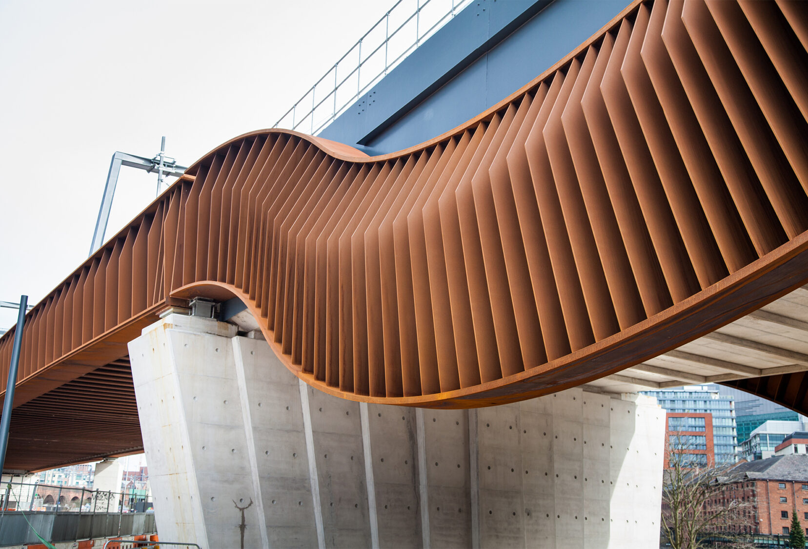 Close view of the curvaceous form of the bridge, made of weathering steel