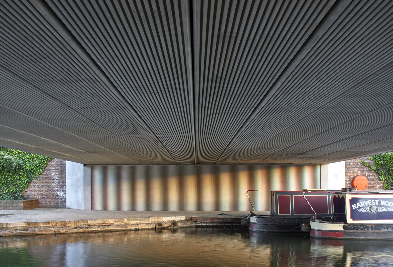 Abutment of Regents Canal Bridge at Kings Cross with Canal boat on the river