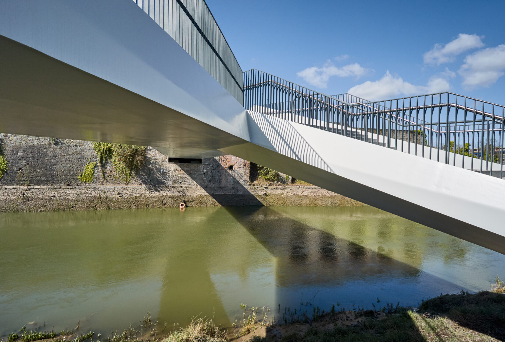 Abutment, edge beam and parapet with river below of footbridge crossing the River Avon